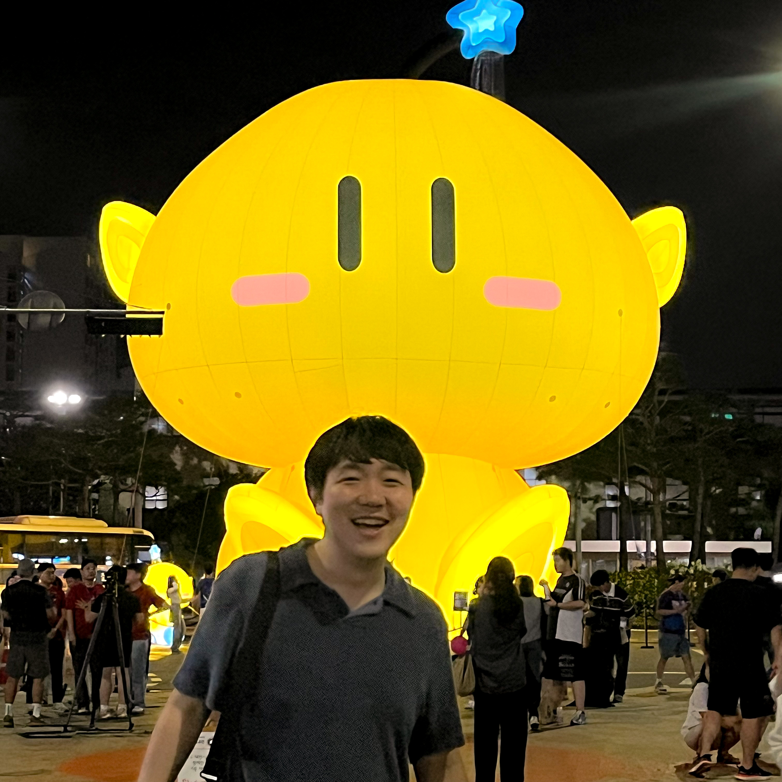 Joonsun Hwang in front of an illuminated yellow sculpture